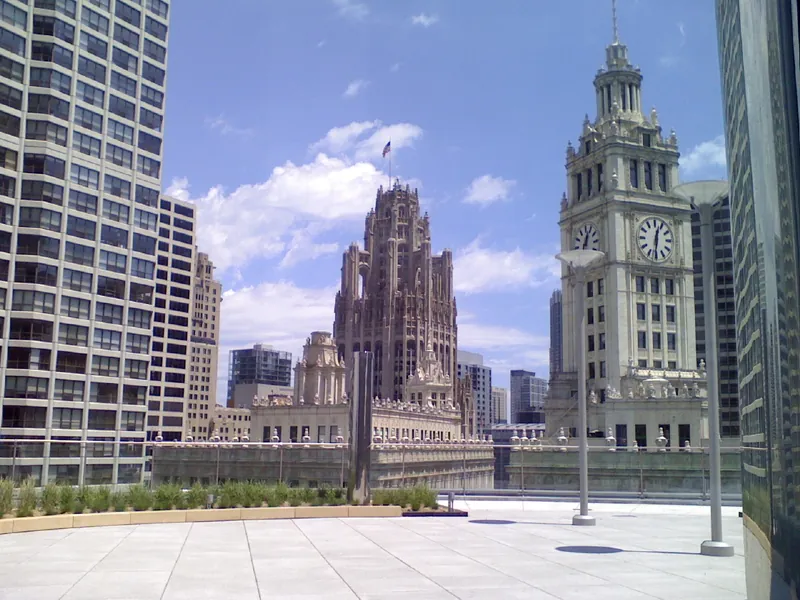 Wrigley Building clock tower and Tribune Tower under a blue sky